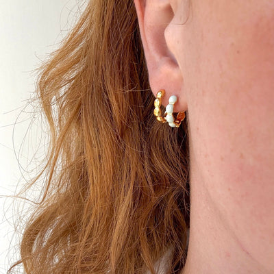 Små øreringe i guld og blå